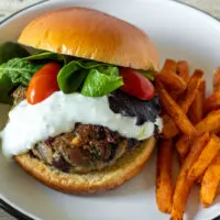 Greek turkey burger with yogaurt sauce and sweet potatoe fries.