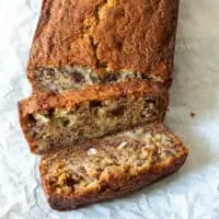 Overhead view of banana bread loaf with two slices cut away.