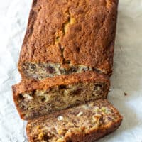 Overhead of banana bread with two slices cut and shown.
