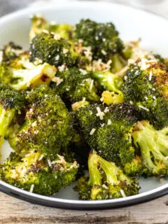 Oven roasted broccoli in serving dish with parmesan.