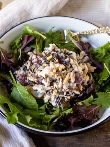 Mound of wild rice chicken salad over greens.