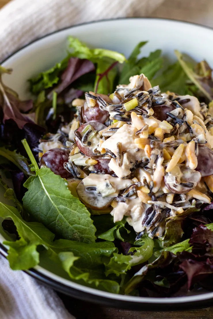 Wild rice chicken salad plated over mixed greens.