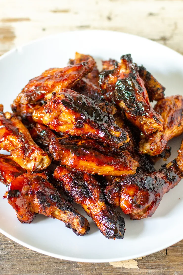 Overhead of grilled chicken wings on serving plate.