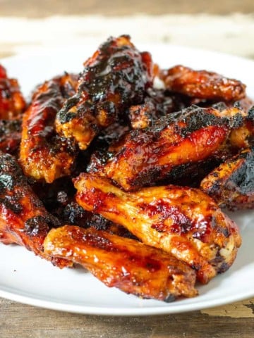 Maple bourbon grilled chicken wings on a serving plate.