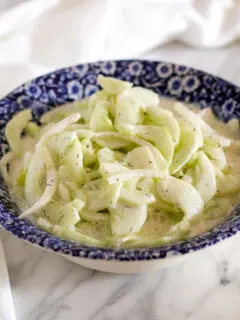 Creamy cucumber salad in serving bowl.