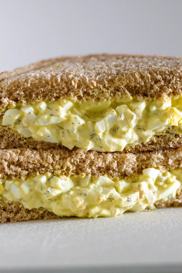 Egg salad sandwich cut in half and stacked.
