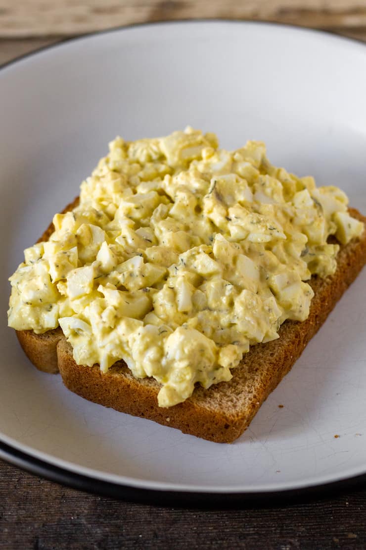 Egg salad mounded on slice of bread.