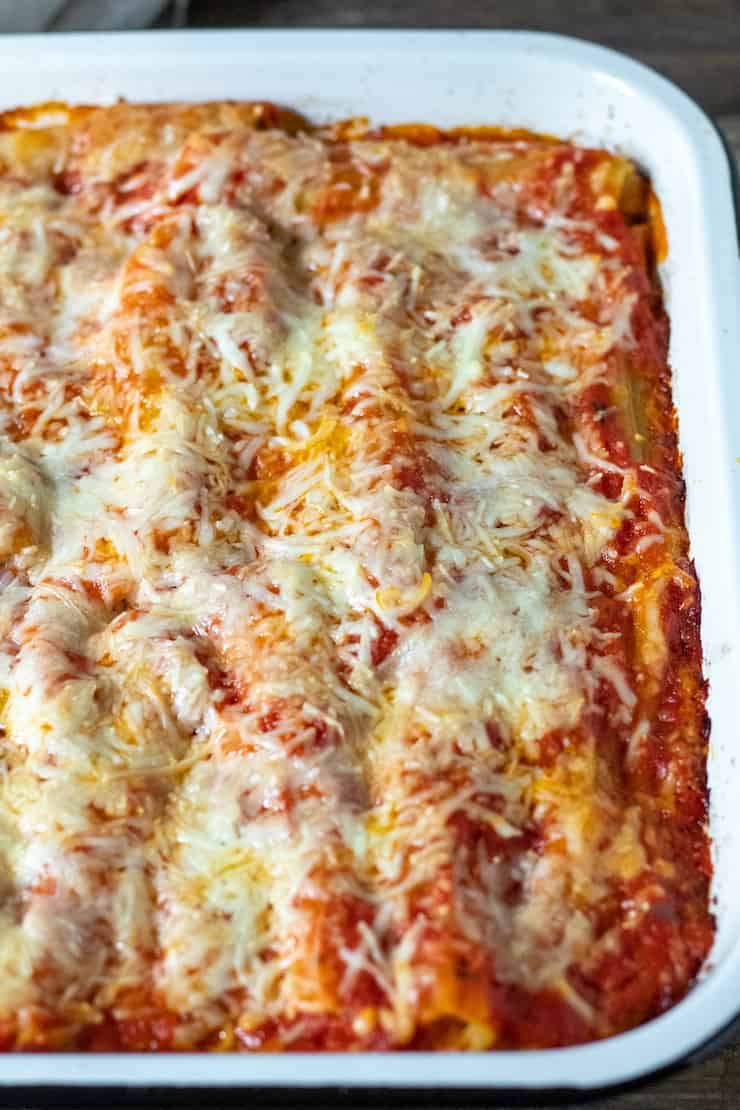 Pan of baked manicotti with melted cheese on top.