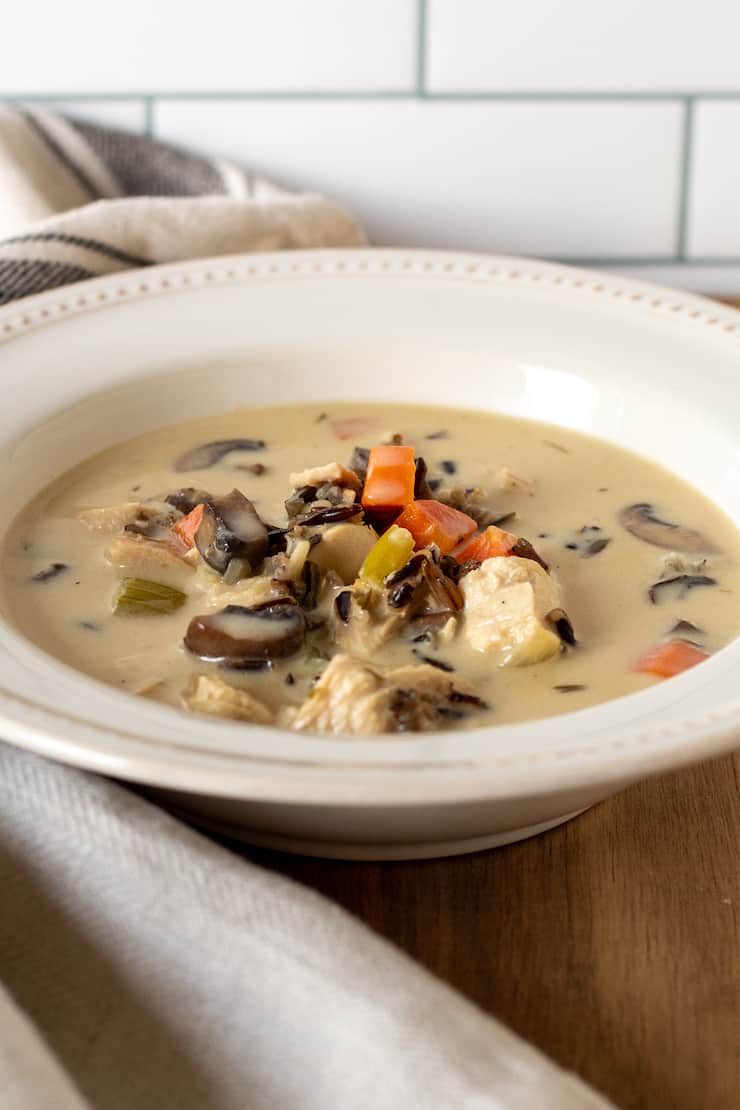 Side view of bowl of creamy chicken wild rice soup.
