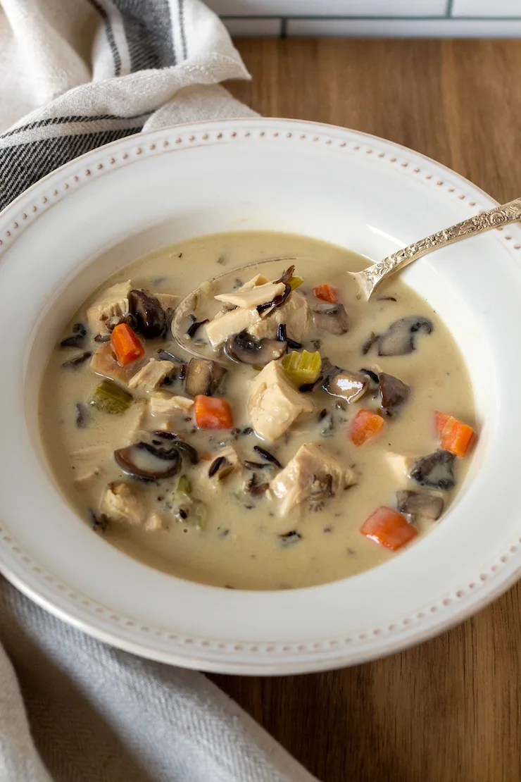 Overhead of bowl of chicken wild rice soup with spoon.