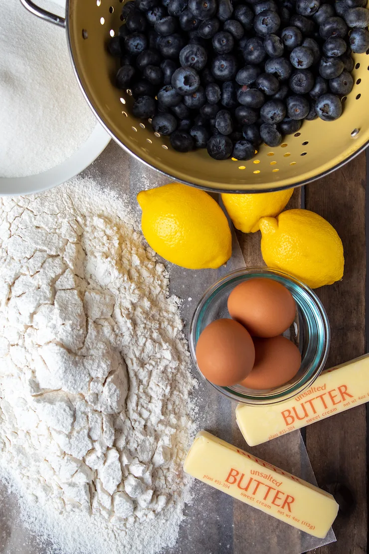 Ingredients photo, sifted flour, sugar, blueberries, lemons, eggs and butter.