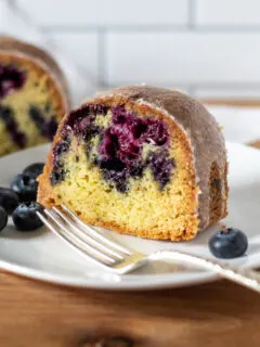 Slice of blueberry lemon Bundt cake on serving plate.