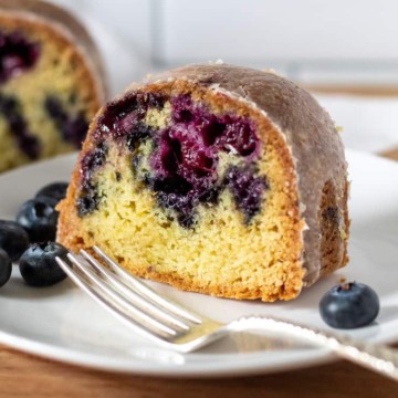Slice of blueberry lemon Bundt cake on serving plate.