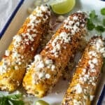 Mexican street corn on platter with lime wedges