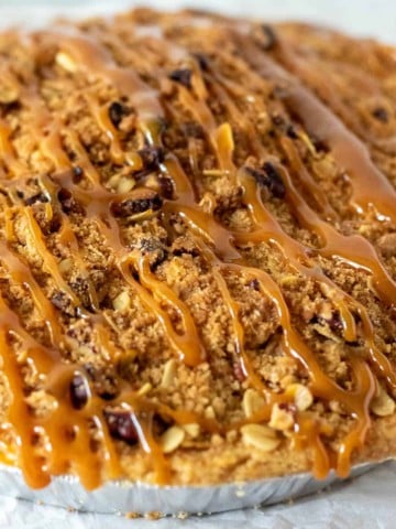 Whole finished Dutch apple pie drizzled with caramel sauce.