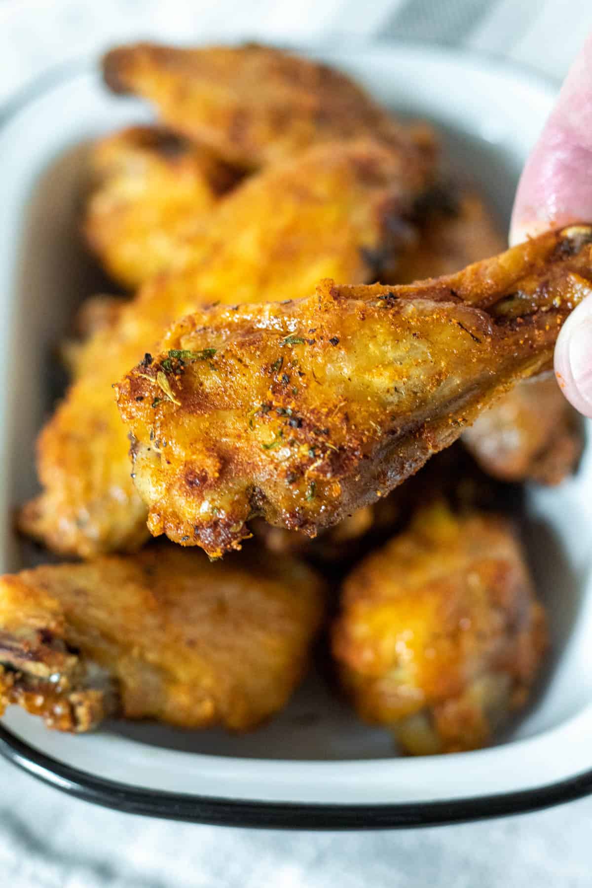Close up of air fried drumette chicken wing portion.