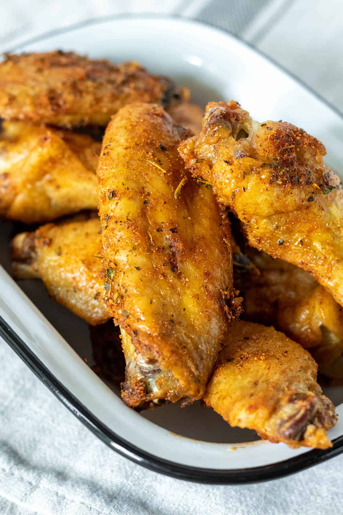 Close up of air fryer chicken wings with seasoning and hot honey.