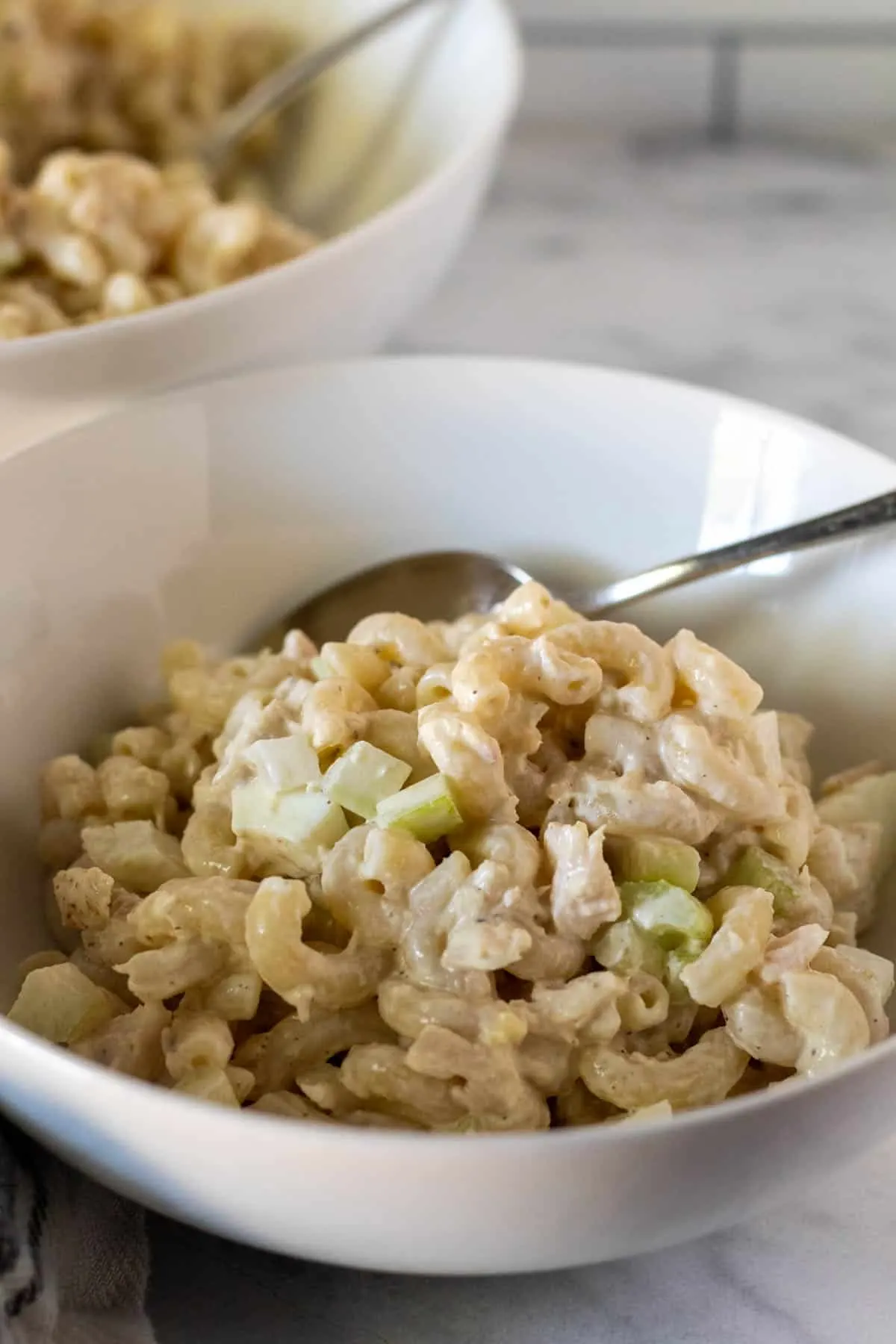 Single serving bowl of tuna pasta salad with spoon.