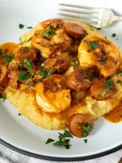 Shrimp and grits on plate with fork.