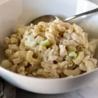 Tuna macaroni salad in white bowl with spoon.