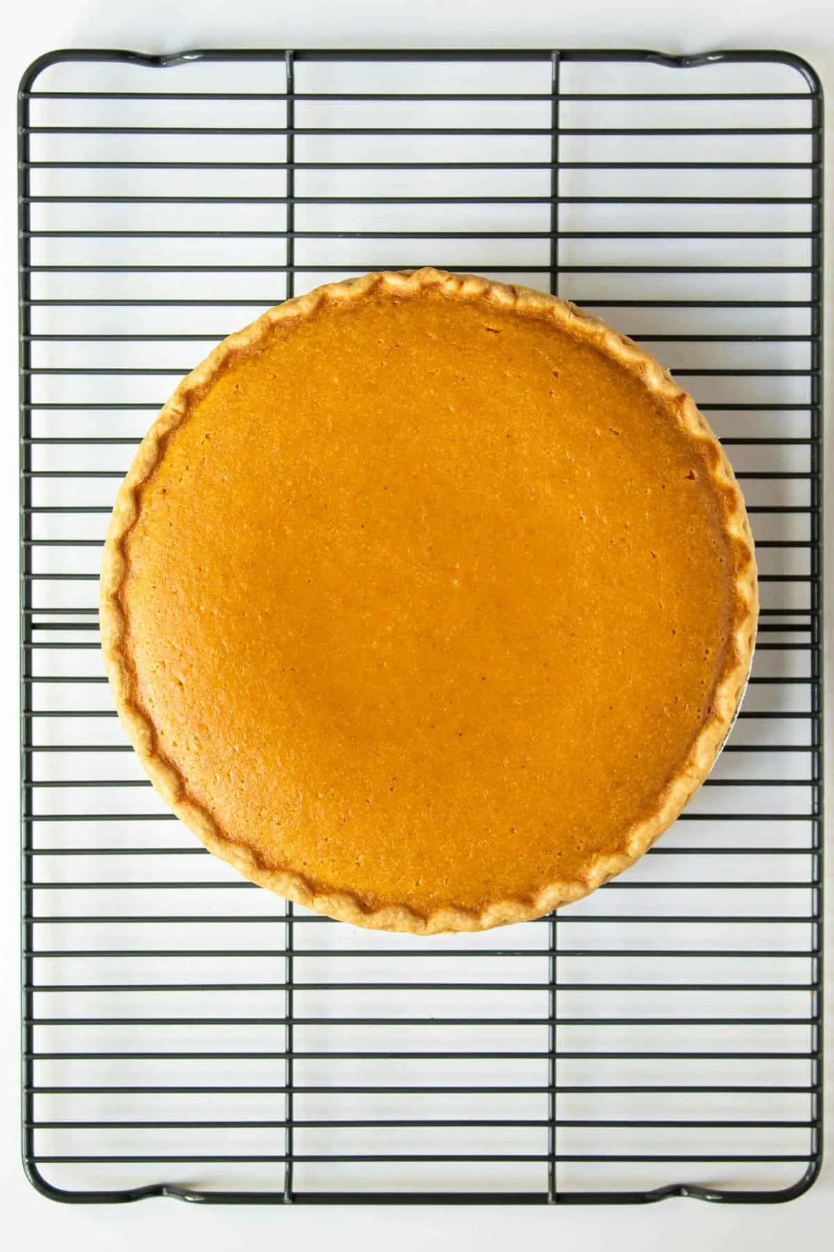 Sweet potato pie cooling on rack after baking.