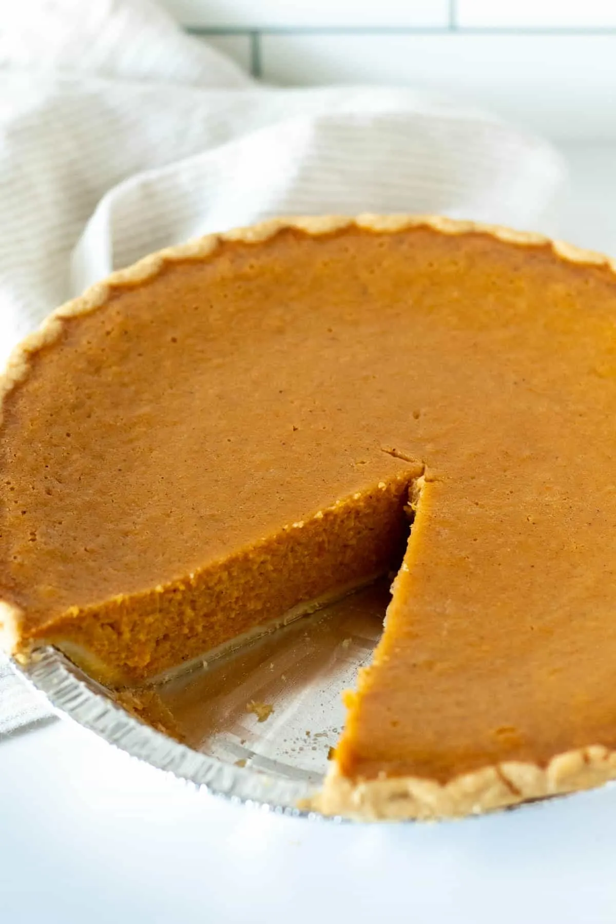 Full sweet potato pie with one piece cut out.