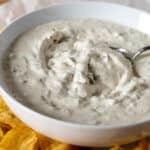 Bowl of dill pickle dip with spoon.