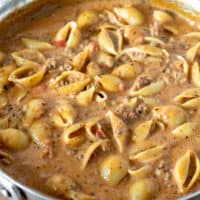 Skillet of cheesy beef and pasta shells.